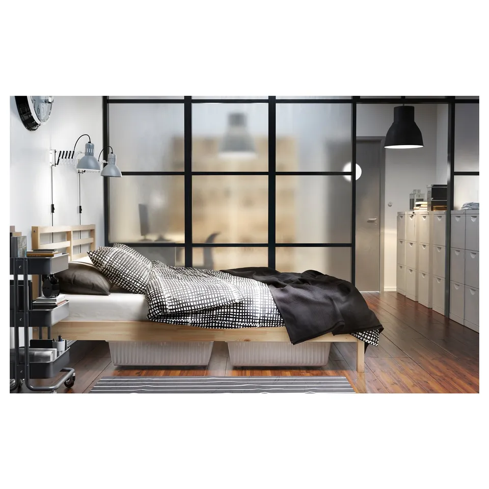 Modern bedroom with TARVA bed, black & white bedding, large windows, wooden floor, grey rug, grey wardrobe, pendant lamp, and wall-mounted lamps.