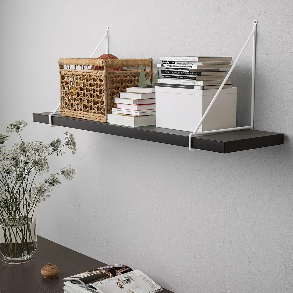 Wall-mounted shelf with books, basket, and vase. Modern design with angled brackets, functional for storage and display.