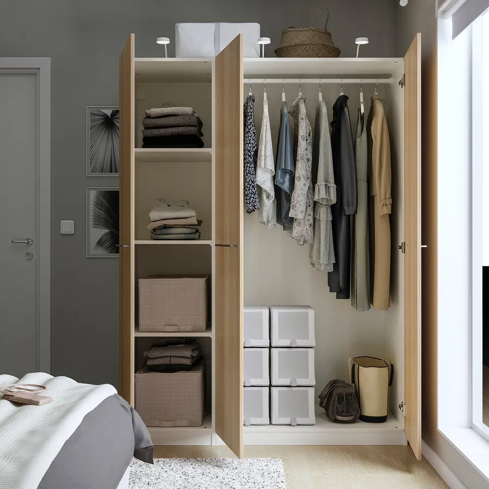 Bedroom closet with mirror doors showing clothes, folded garments, and storage boxes. Hangs about 40 shirts.