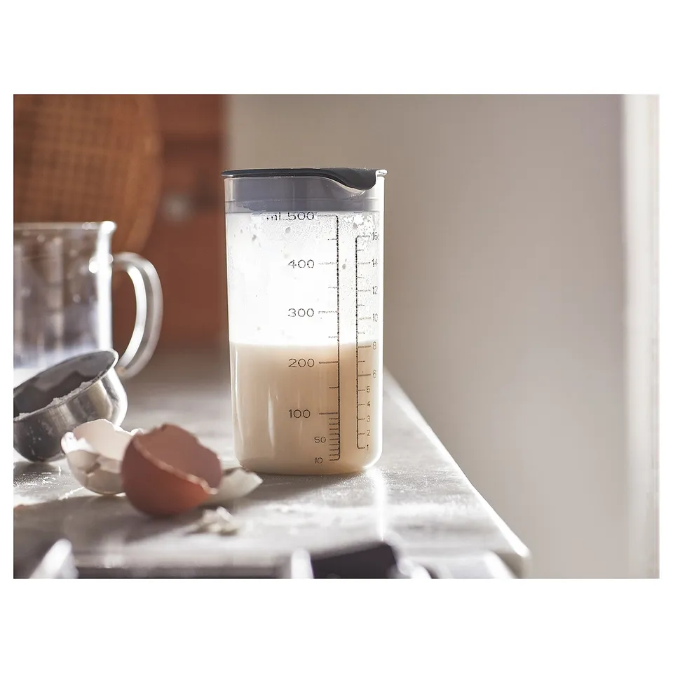 Plastic protein shaker. Graduated markings, leak-proof lid. Standing on countertop.