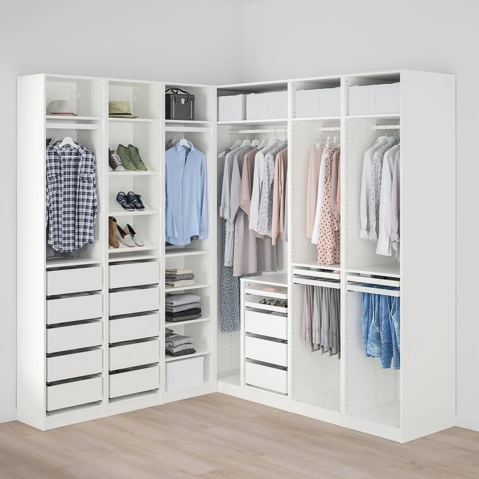 A well-organized white corner closet with shelves, drawers, and hanging space, maximising storage efficiently.
