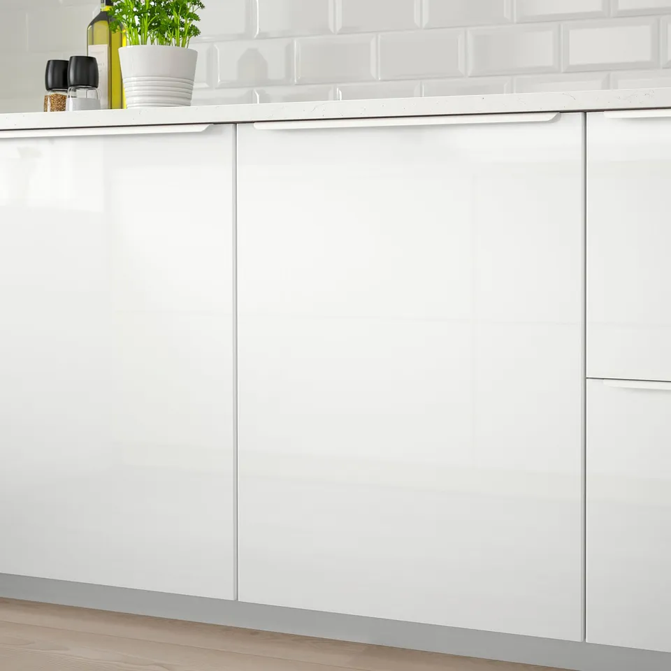 Modern kitchen with RINGHULT cabinets, integrated dishwasher, green bottle, plant.