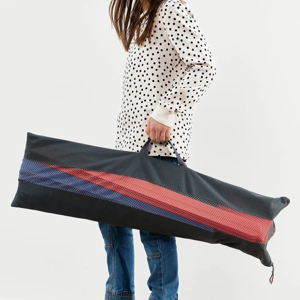 A person holding an obstacle course bag with colourful hurdles and cones.