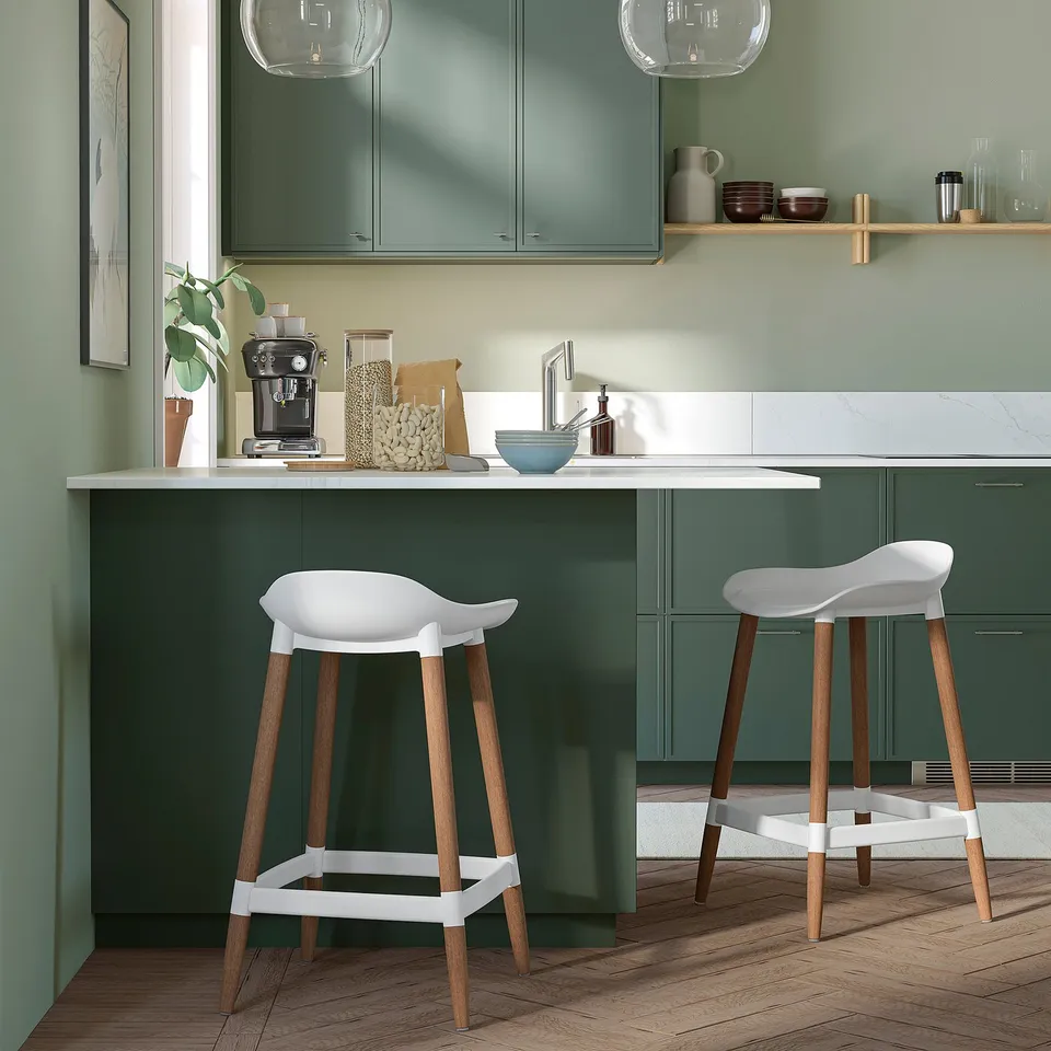 Modern kitchen with 2 white GRÖNSTA barstools at green island.