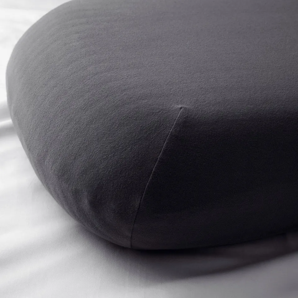 Round, dark grey pillowcase with smooth fabric, likely cotton blend, showcasing a clean, elastic edge design.