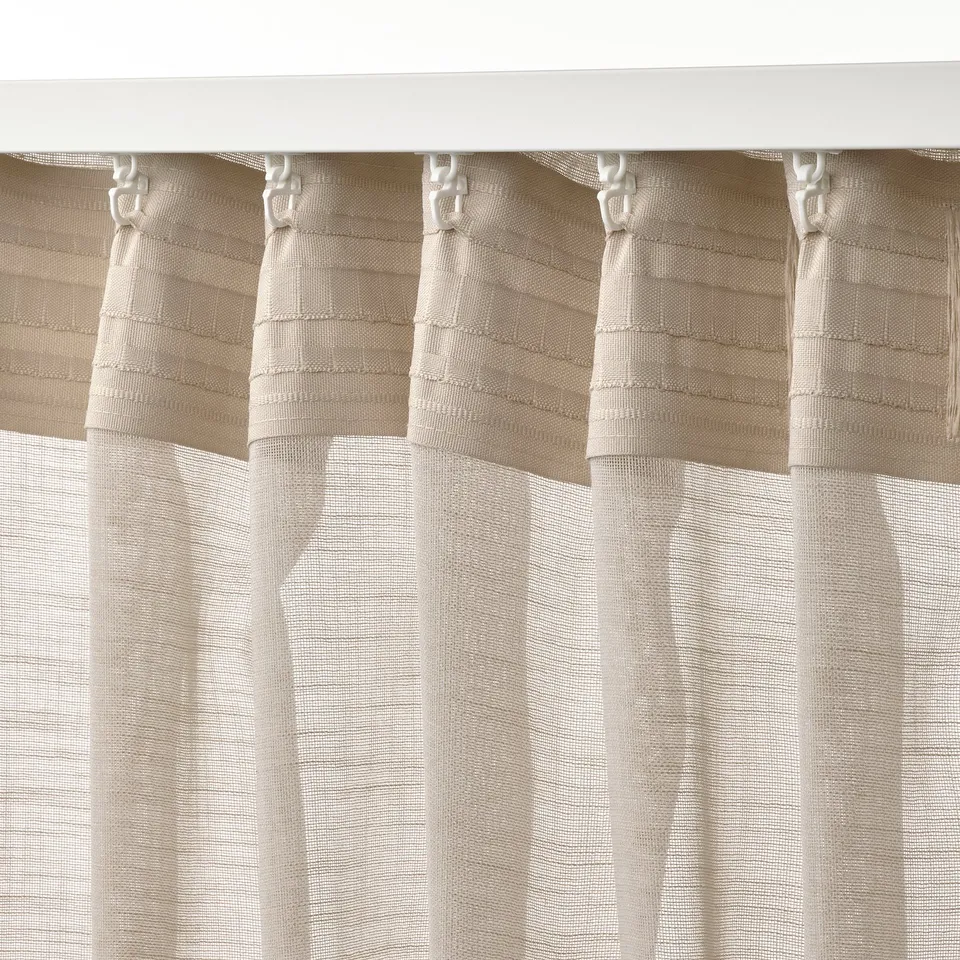 Beige sheer curtains shown with hooks, creating pleats. Allows light, offers privacy.