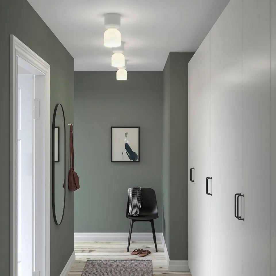 Modern green hallway with HAMNFYR lamps, chair, mirror, and closet.
