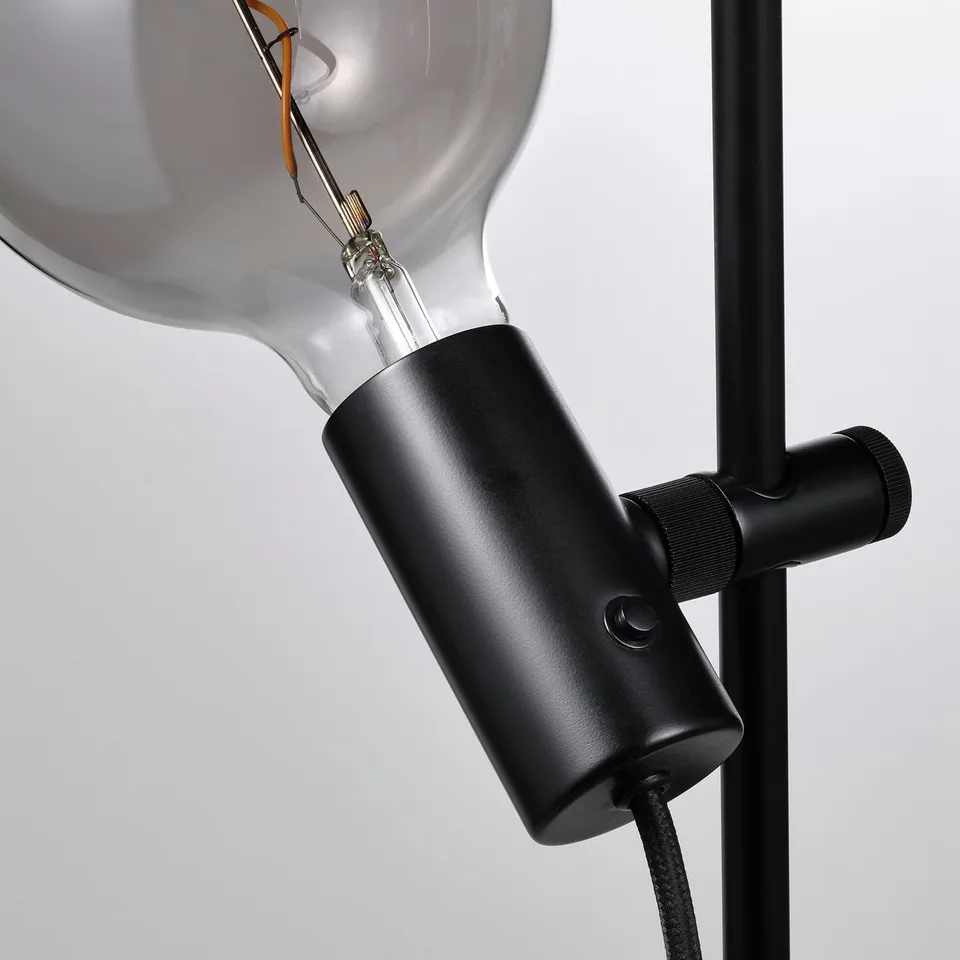 Modern lamp with adjustable, frosted bulb on black metallic base.