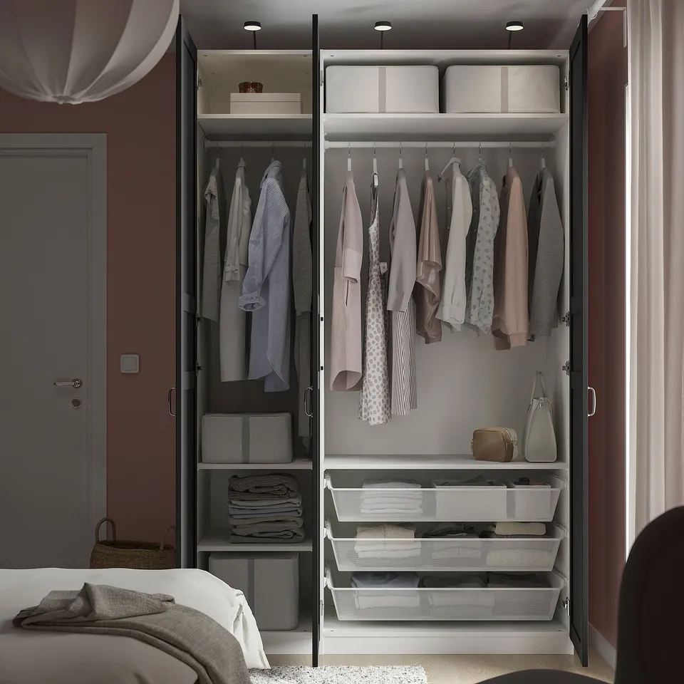 Open wardrobe with clothes, organisers, and storage boxes, demonstrating PAXs modular storage solution.