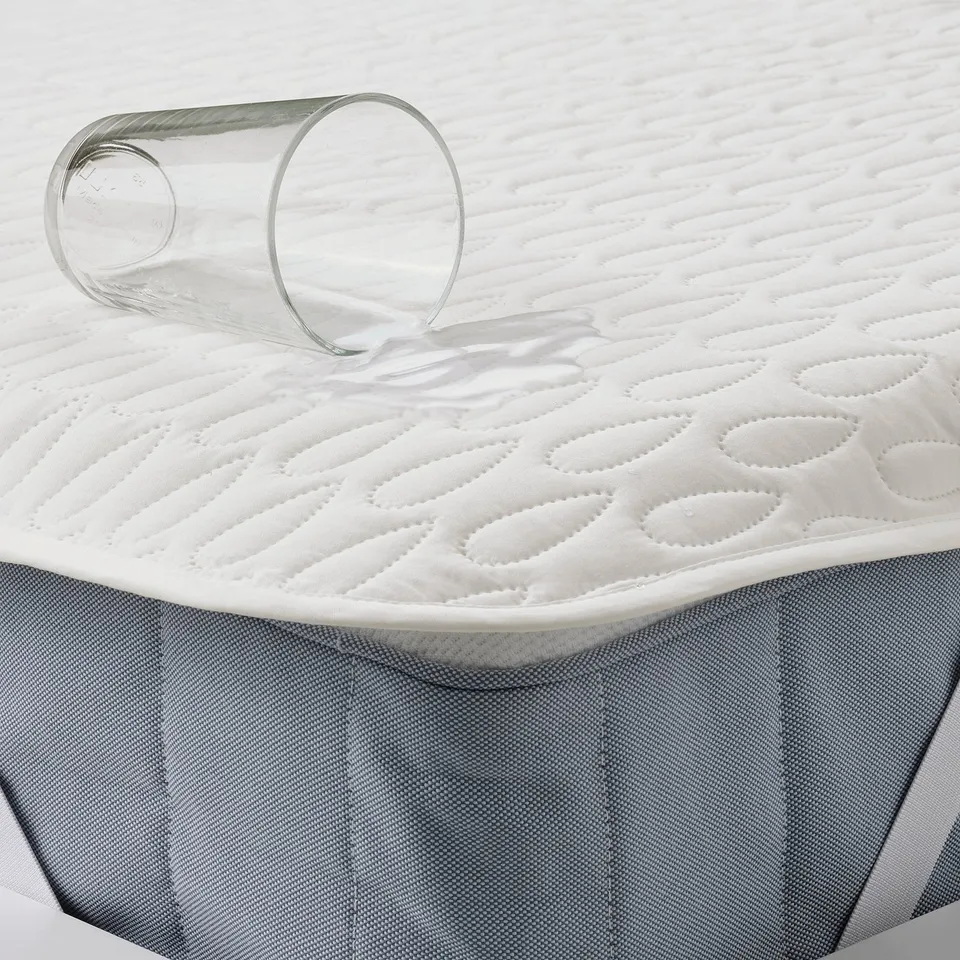 Mattress protector with waterproof layer, preventing liquid absorption and spills, showcasing soft wadding design.