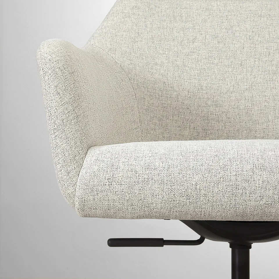 Close-up of cosy swivel chairs padded arm and seat, showcasing durable fabric and soft design.