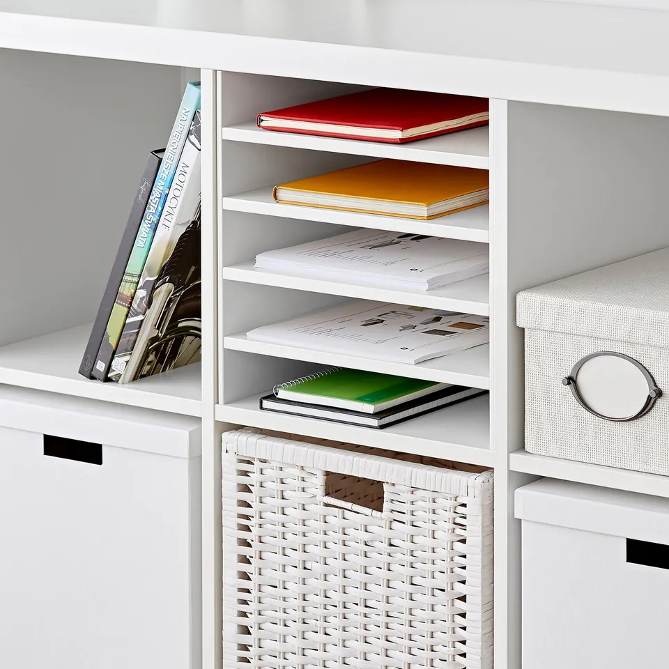 White KALLAX shelf with books and basket. Four additional shelves hold notebooks and folders, showcasing organised storage.