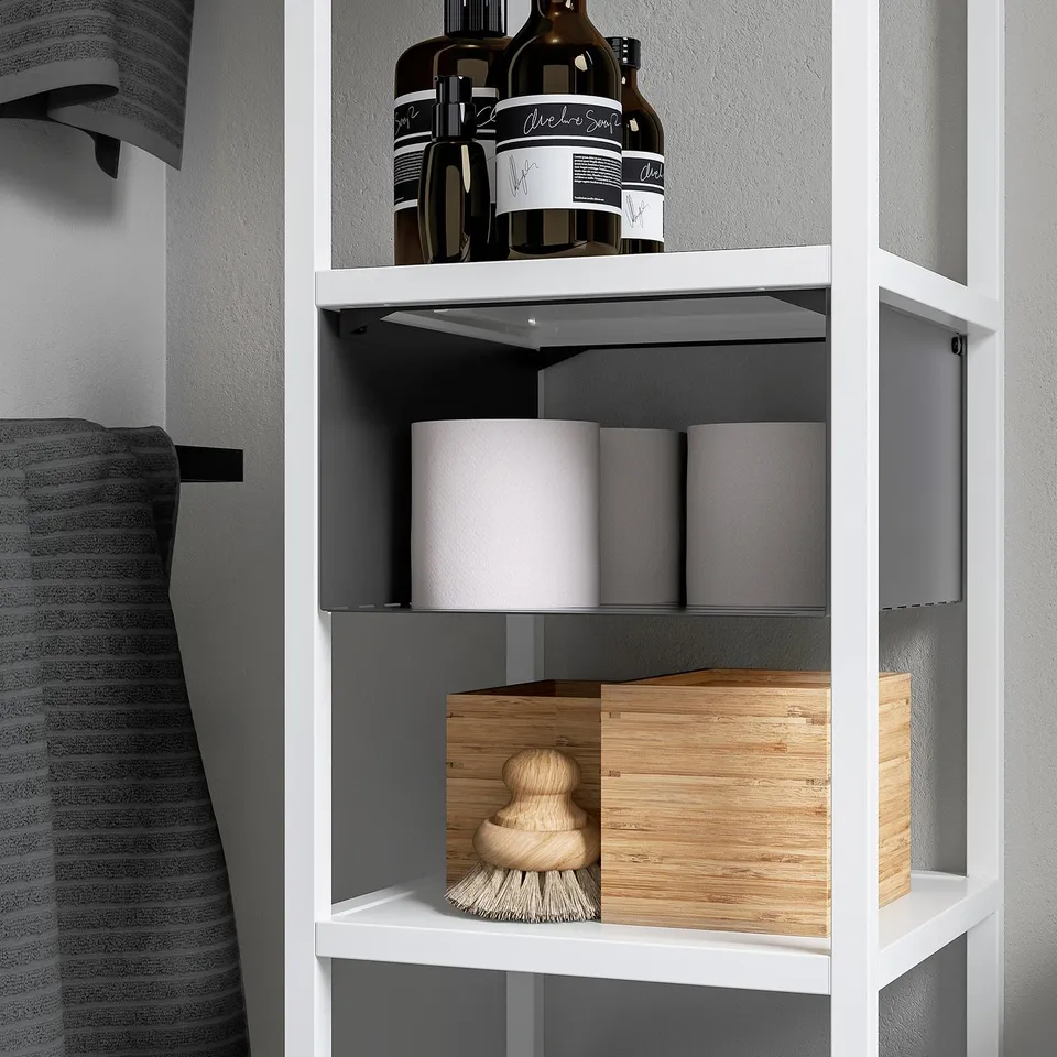 White ENHET shelf insert divides space on a wall shelf, holding bottles and storage boxes neatly.