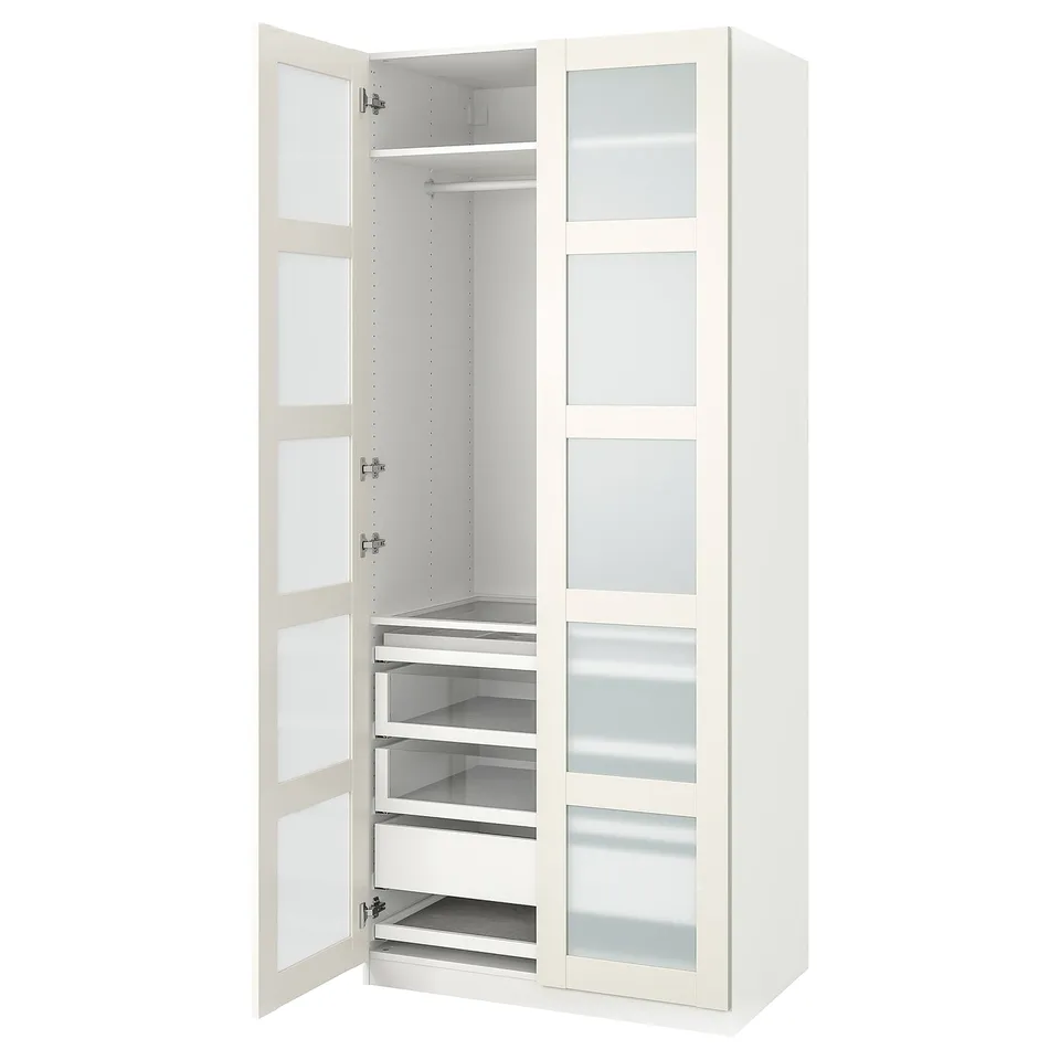 A white ikea PAX wardrobe with glass doors and drawers. It has a sleek modern design.