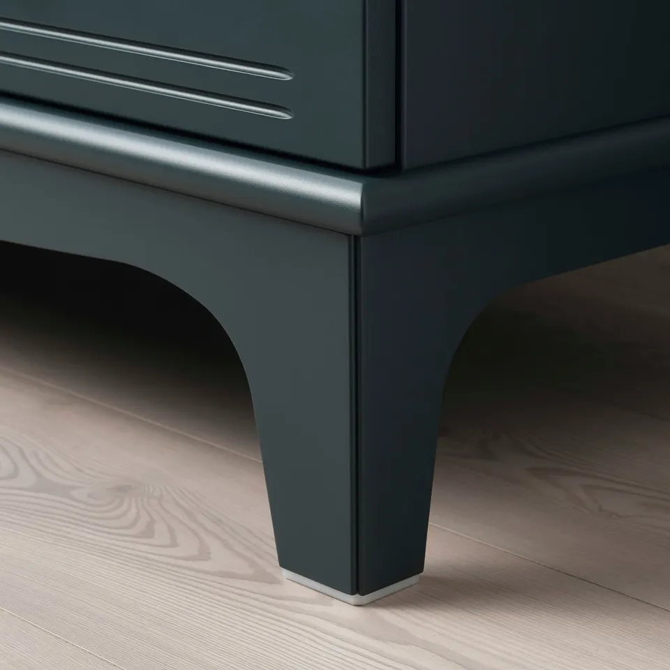 Close-up of dark green LOMMARP cabinet leg with sleek, polished finish. Its positioned on stylish, wooden flooring.