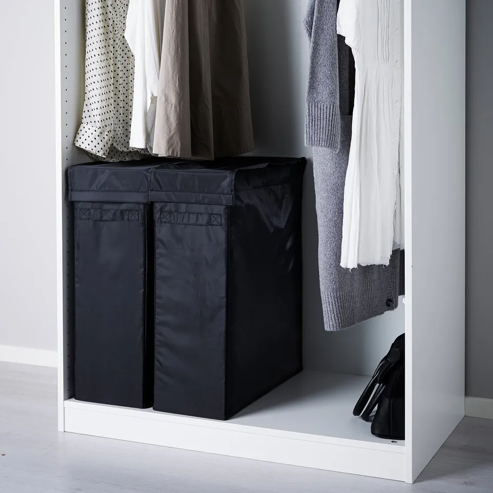 Black SKUBB laundry bags in wardrobe storing clothes and keeping floor clean.