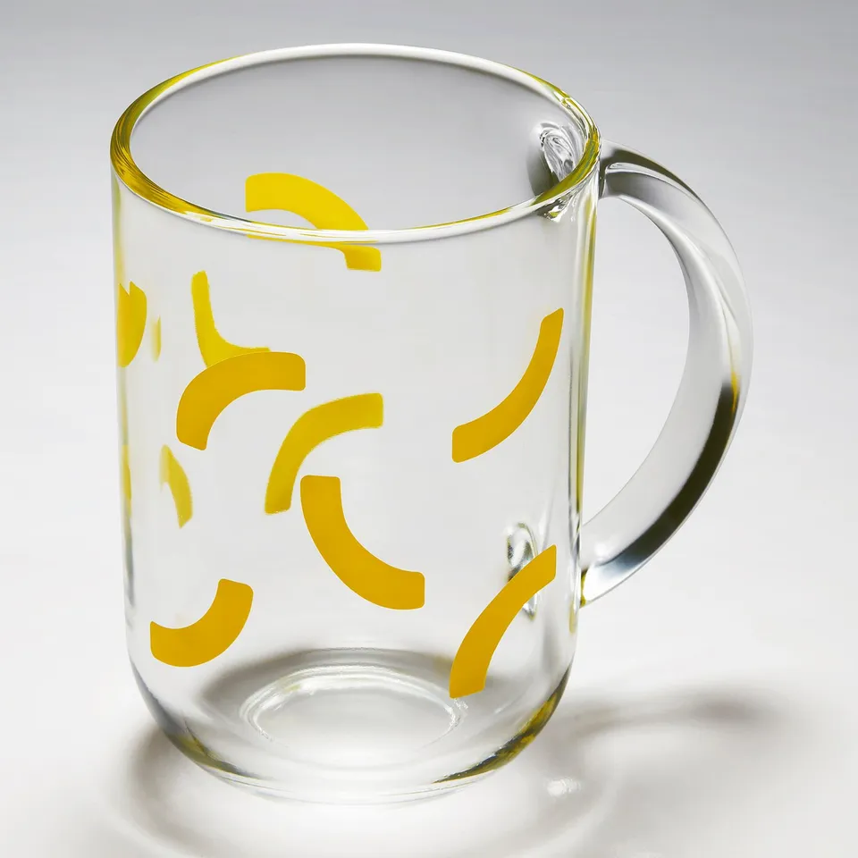 Clear glass mug with bright yellow swirl patterns, sturdy handle, high-quality tempered glass.