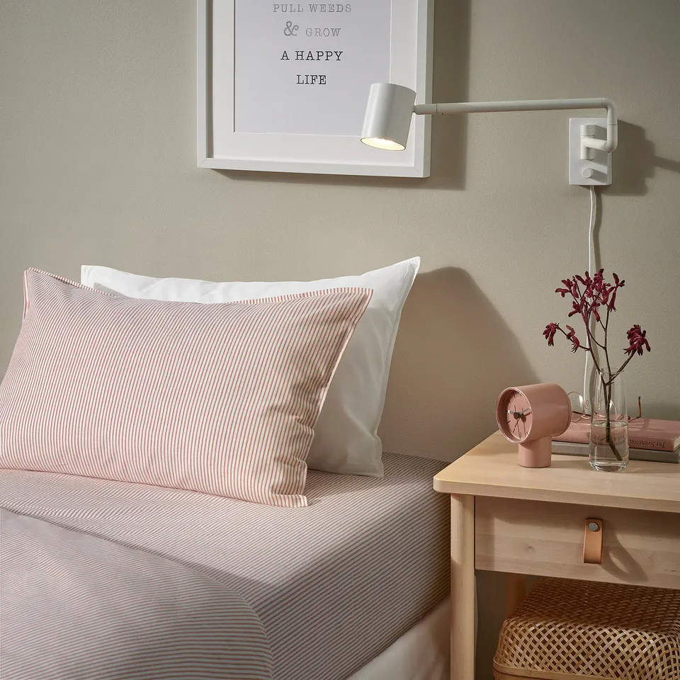 Bedroom with SOLFIBBLA striped bedspread, quote art, and pink details.