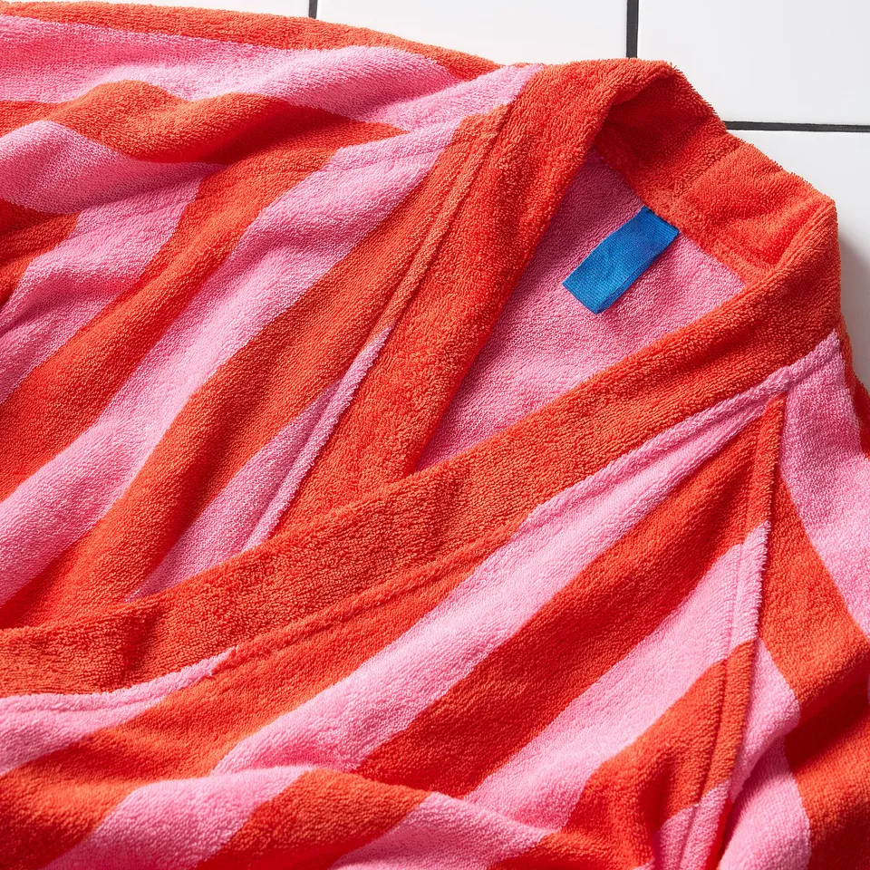 Striped bathrobe displayed on hanger; soft, absorbent cotton; red and pink stripes.