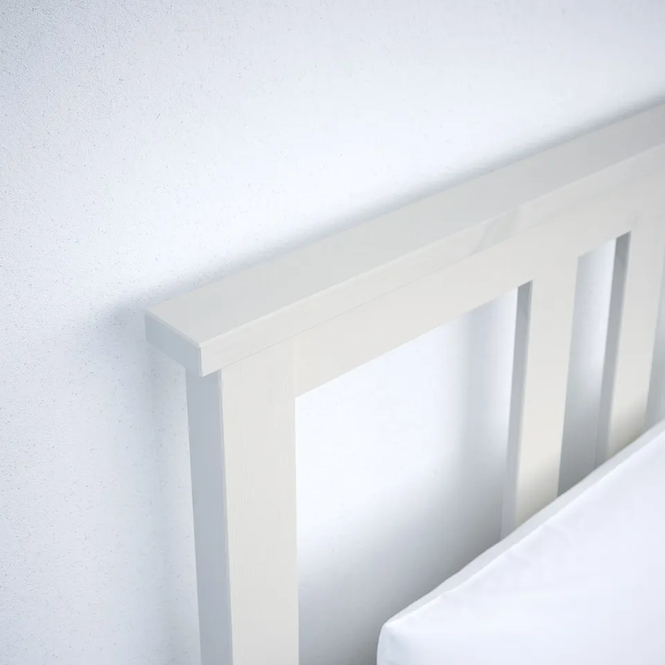 Close-up of white wooden bed frame, smooth and robust with glossy finish.