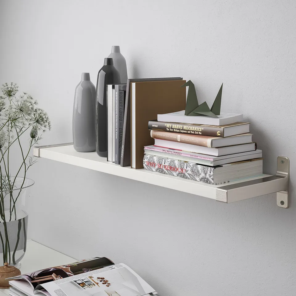 White wall-mountable shelf holding books and vases; BERGSHULT.