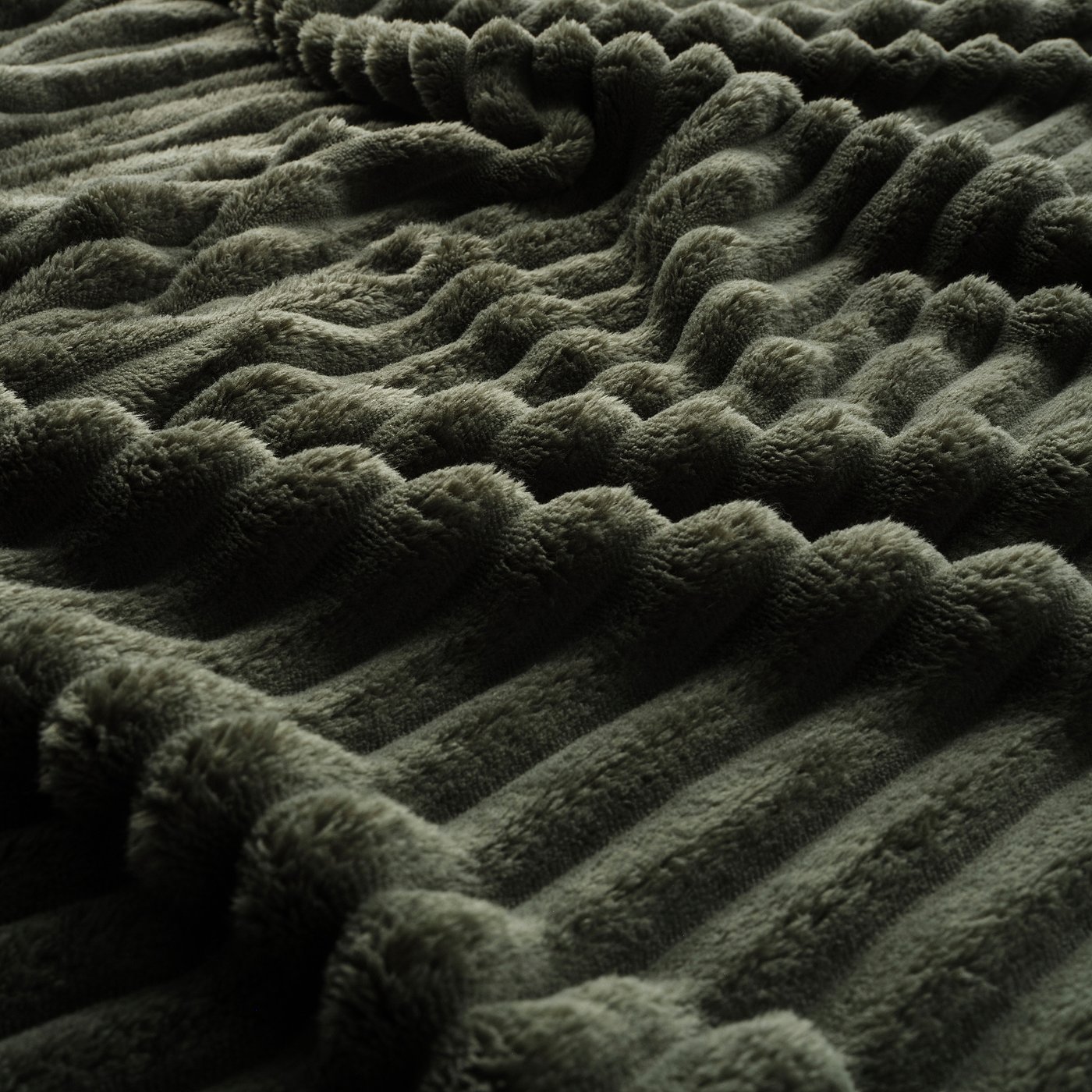 Soft, textured green blanket with zudem wave pattern in recycled polyester.