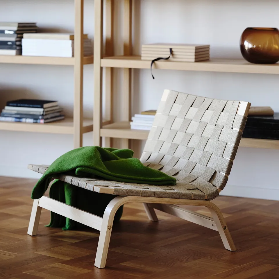 Modern scandinavian chair STOCKHOLM 2025 in beige linen with birch wood frame. Green blanket, minimalist design, smaller than bookshelf.