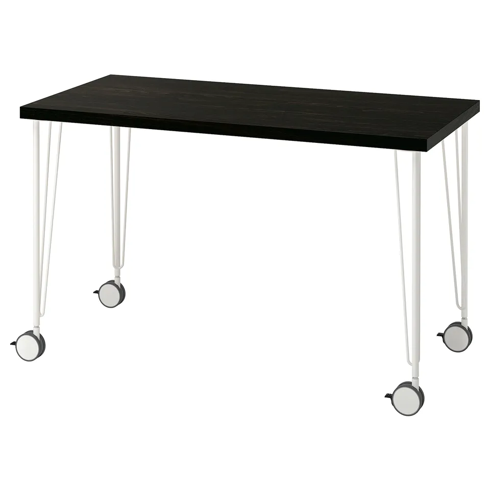 A LAGKAPTEN desk with a dark tabletop and white metal legs featuring built-in castors.