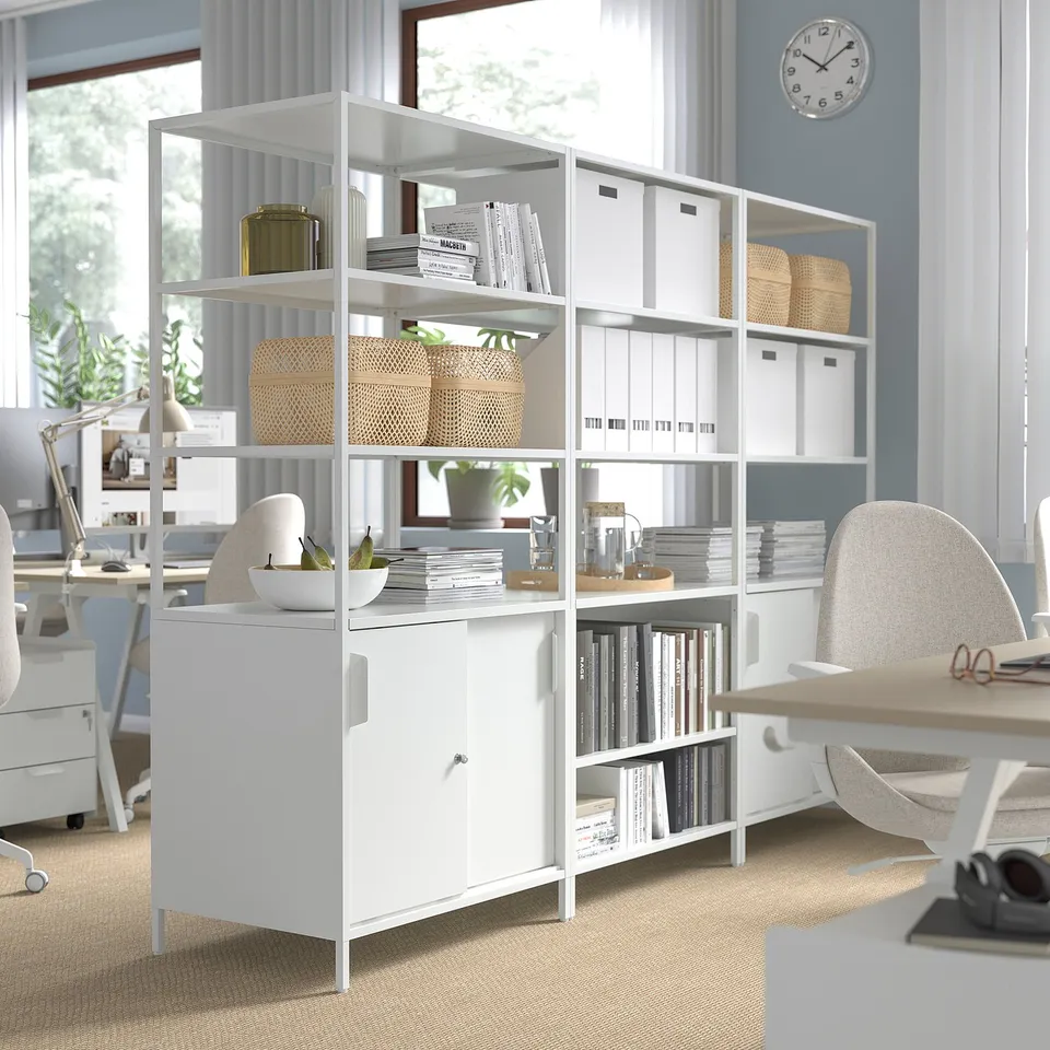 White office storage cabinets with open and closed sections, separating workspace, organising books, and providing a room divider.