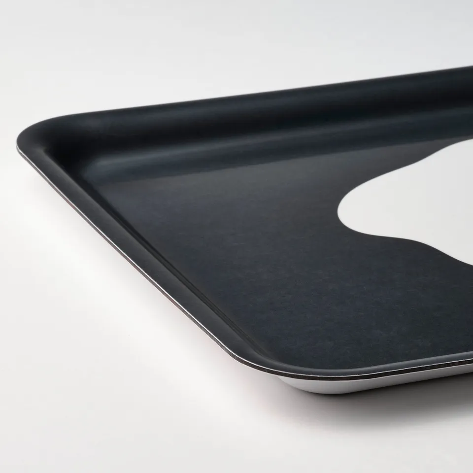 Black tray with sleek, angled edges on a white surface. High-quality design, both practical and stylish.