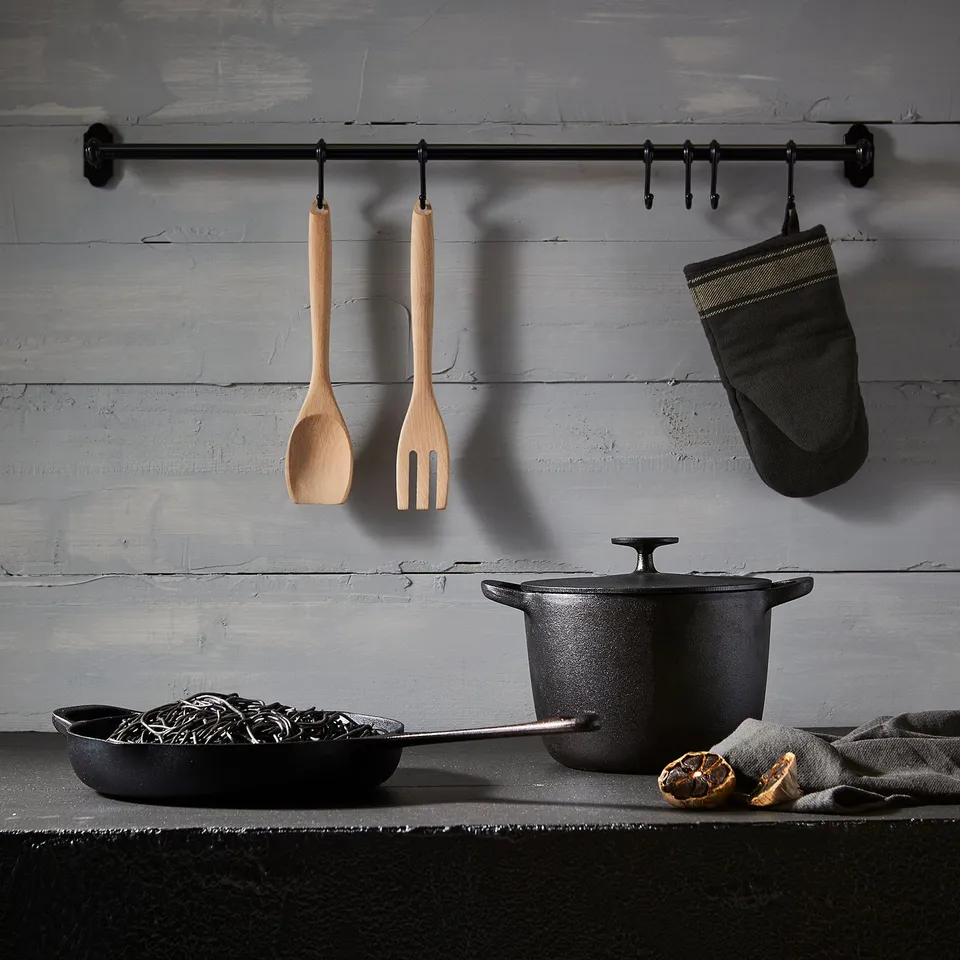 Kitchen setup with RÖRT non-stick pots, wooden utensils, and hanging oven mitt.
