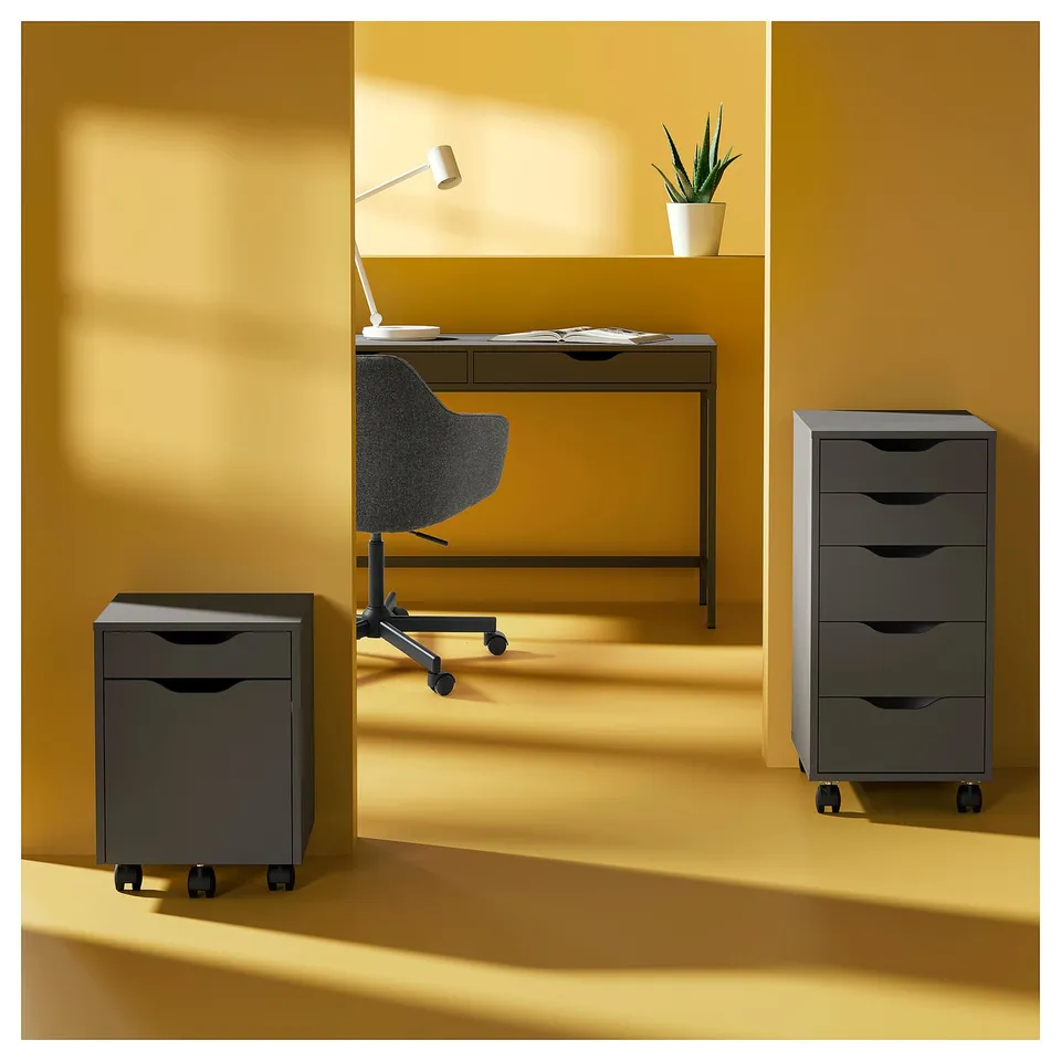 Prepared desk with ALEX grey drawers, chair, and lamp; plant on shelf.