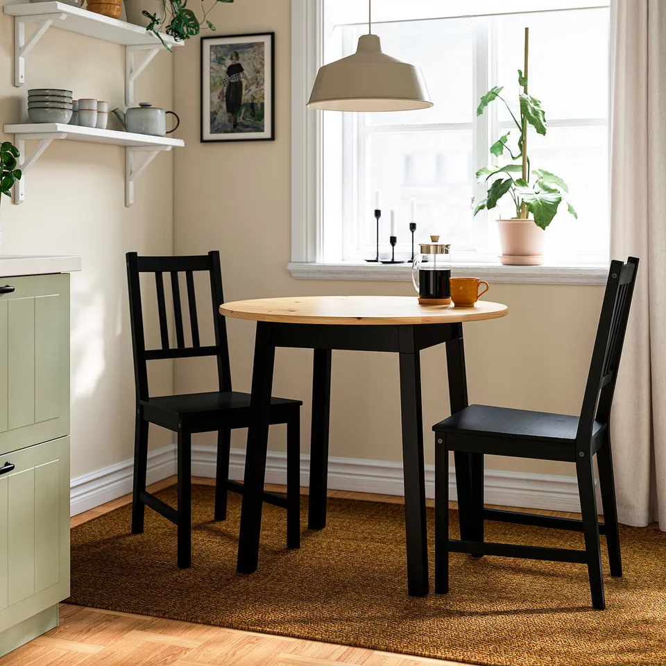 Compact dining table & chairs with coffee set under a window.