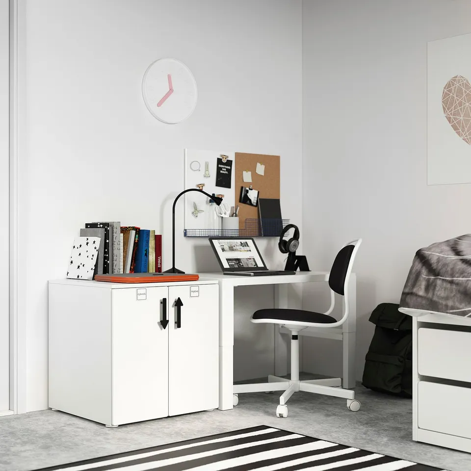 Small white study area setup with books, laptop, and chair. Modern, minimal design.