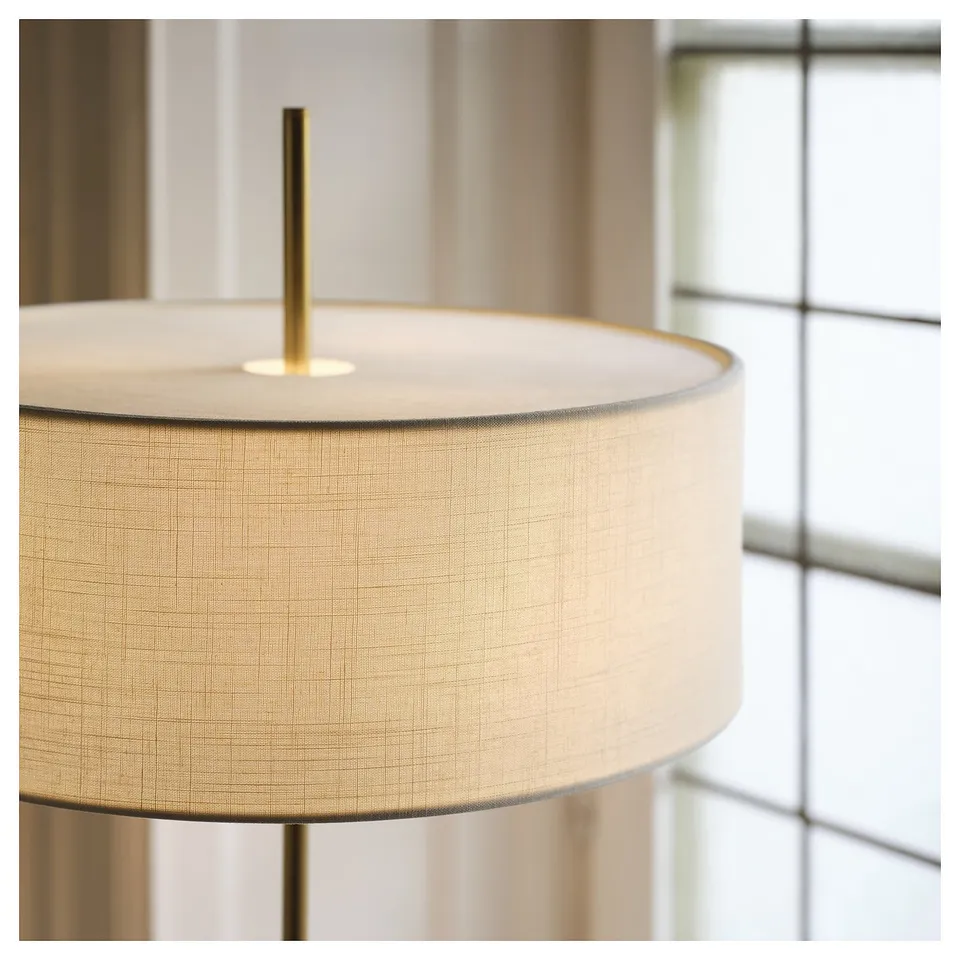 Large floor lamp with beige shade, brass pole, on white background.