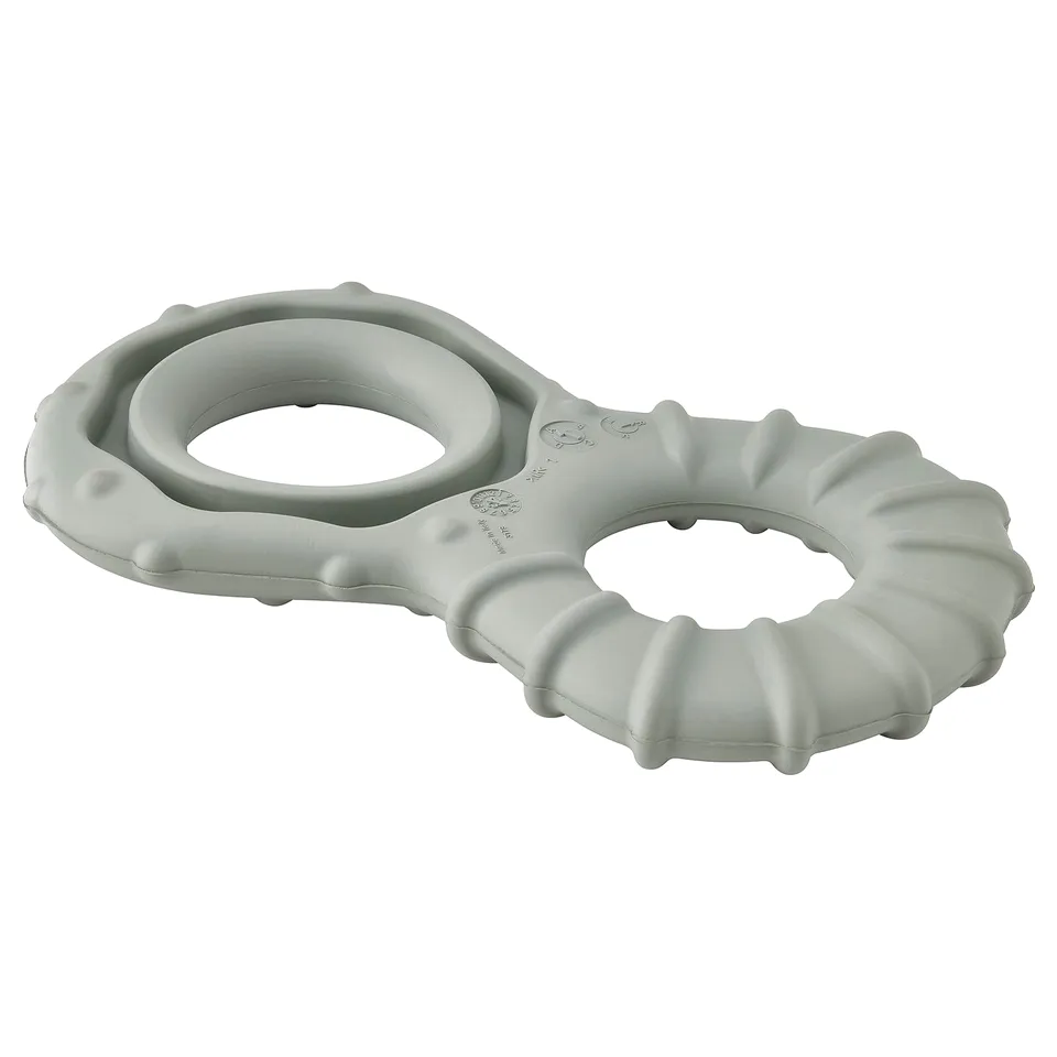 A grey UTSÅDD dog toy made of natural rubber. It has a ring shape with textured surfaces and a hollow centre for hiding treats.