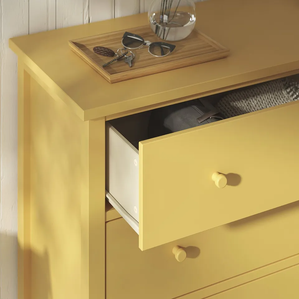 Bright yellow GULLABERG dresser with open drawer, knobs, keys, glasses, and tray on top.