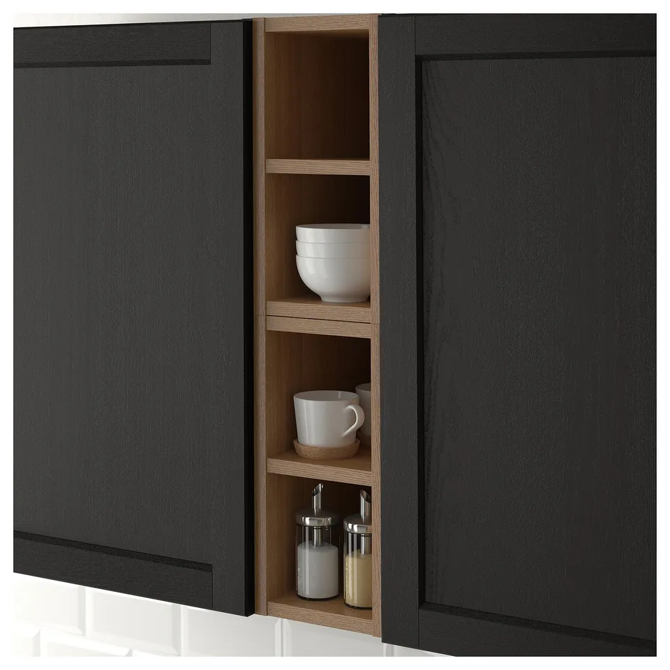 Black kitchen cabinet with open section displaying bowls, mugs, and spice jars, offering easy access and organisation.