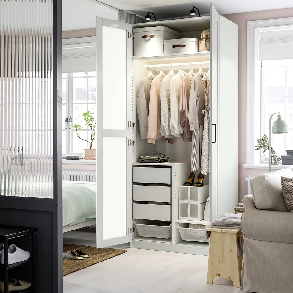 An open wardrobe displaying clothes, drawers, and baskets, showcasing organised storage.