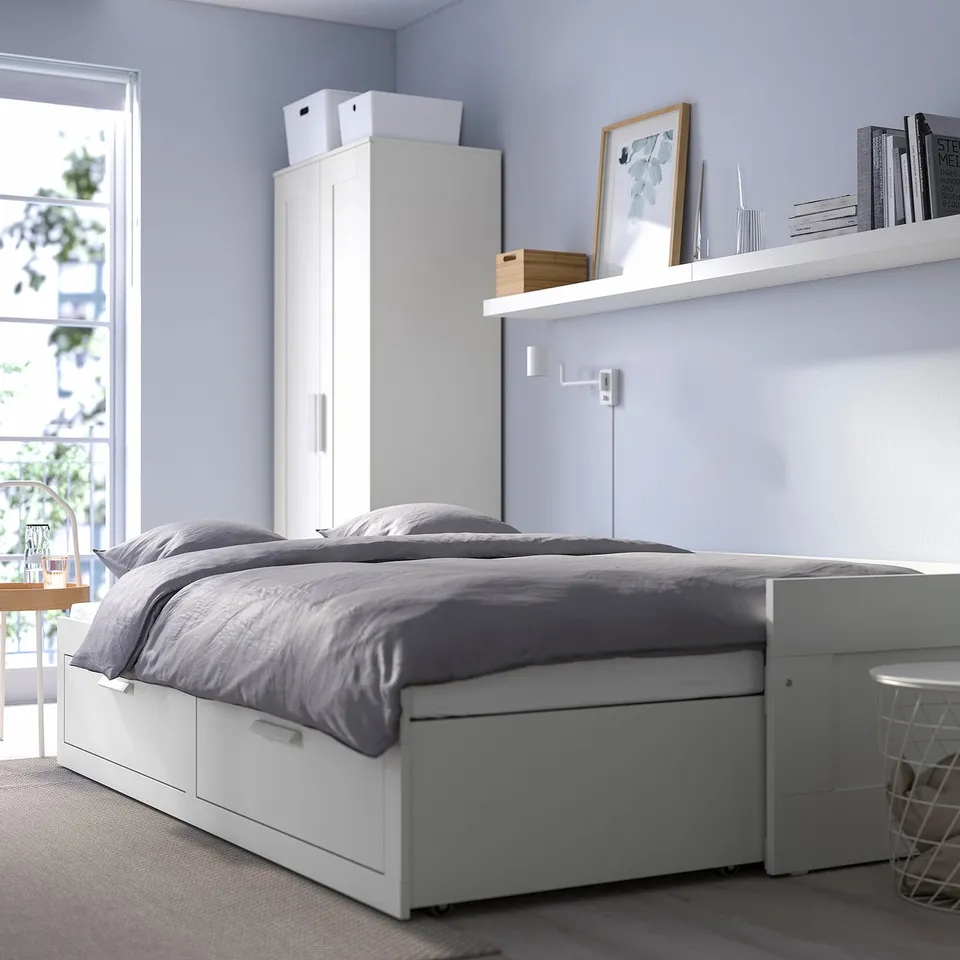 Modern bedroom with white BRIMNES day-bed, grey linen, two drawers, and tall wardrobe.