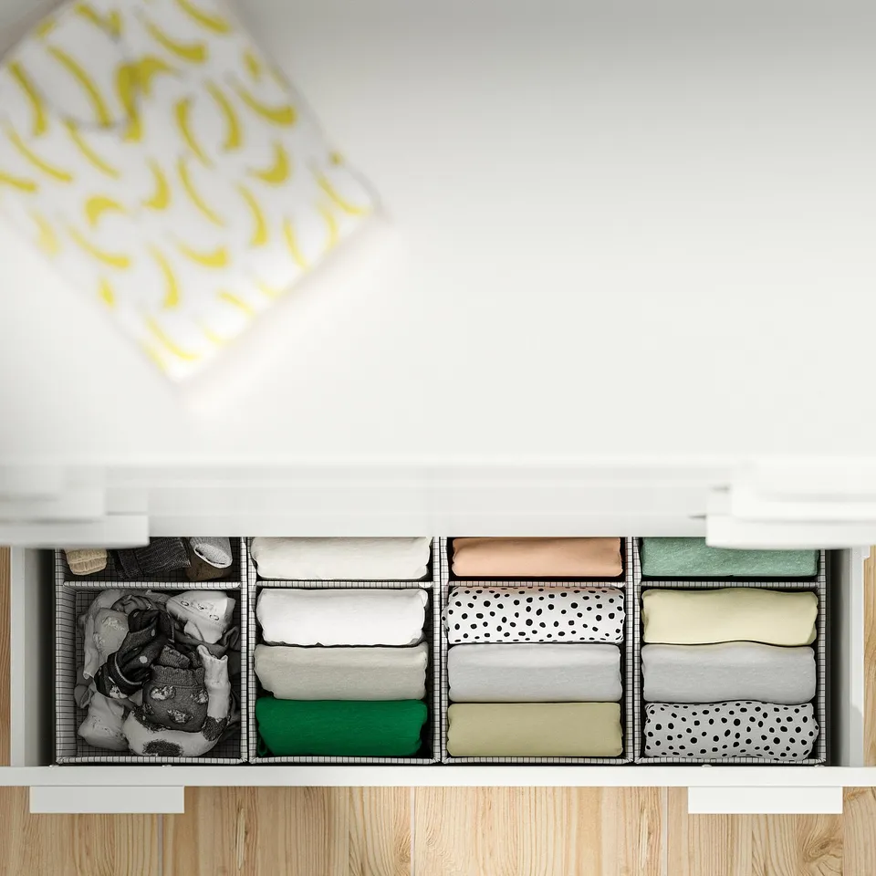 Open drawer organiser with neatly folded clothes in compartments.