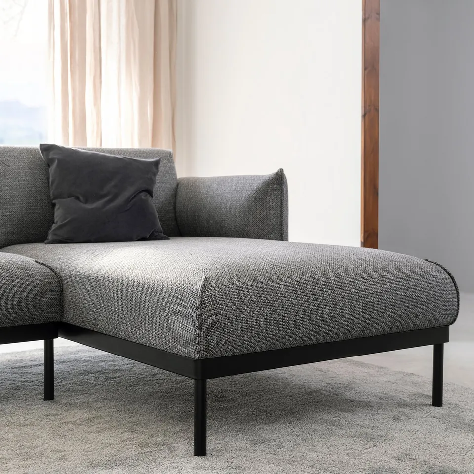 Modern grey fabric sofa with black metal legs. Soft cushions, clean lines, stylish and comfortable.