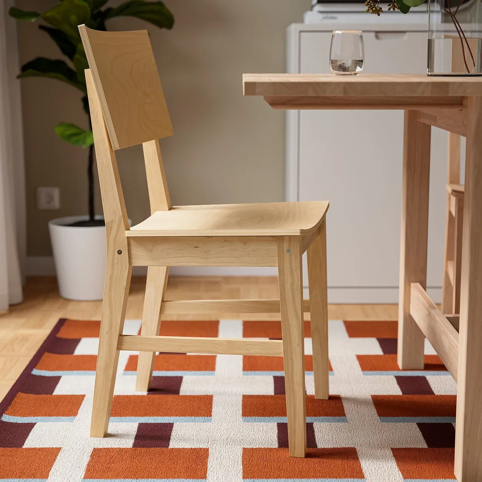 Wooden dining chair on patterned rug. Suitable for homes and public settings. Part of 8-seat extendable dining set.