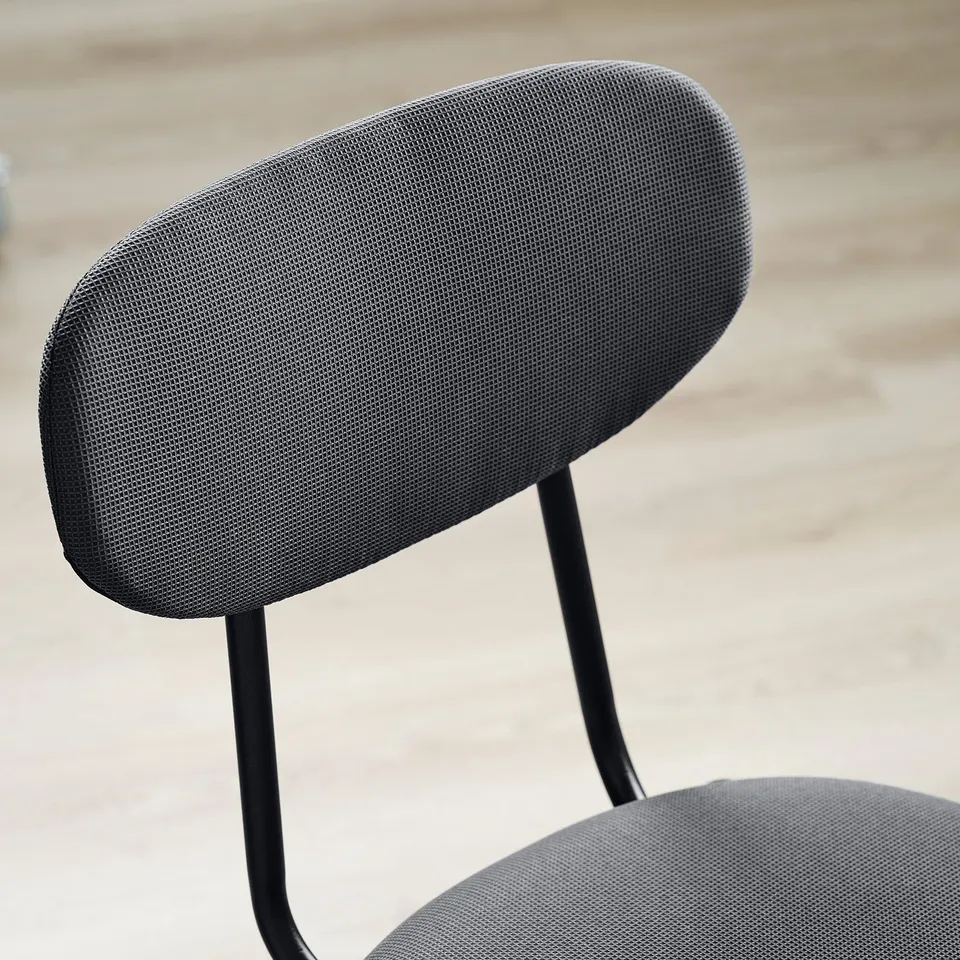 Black mesh office chair, curved back, adjustable armrests.