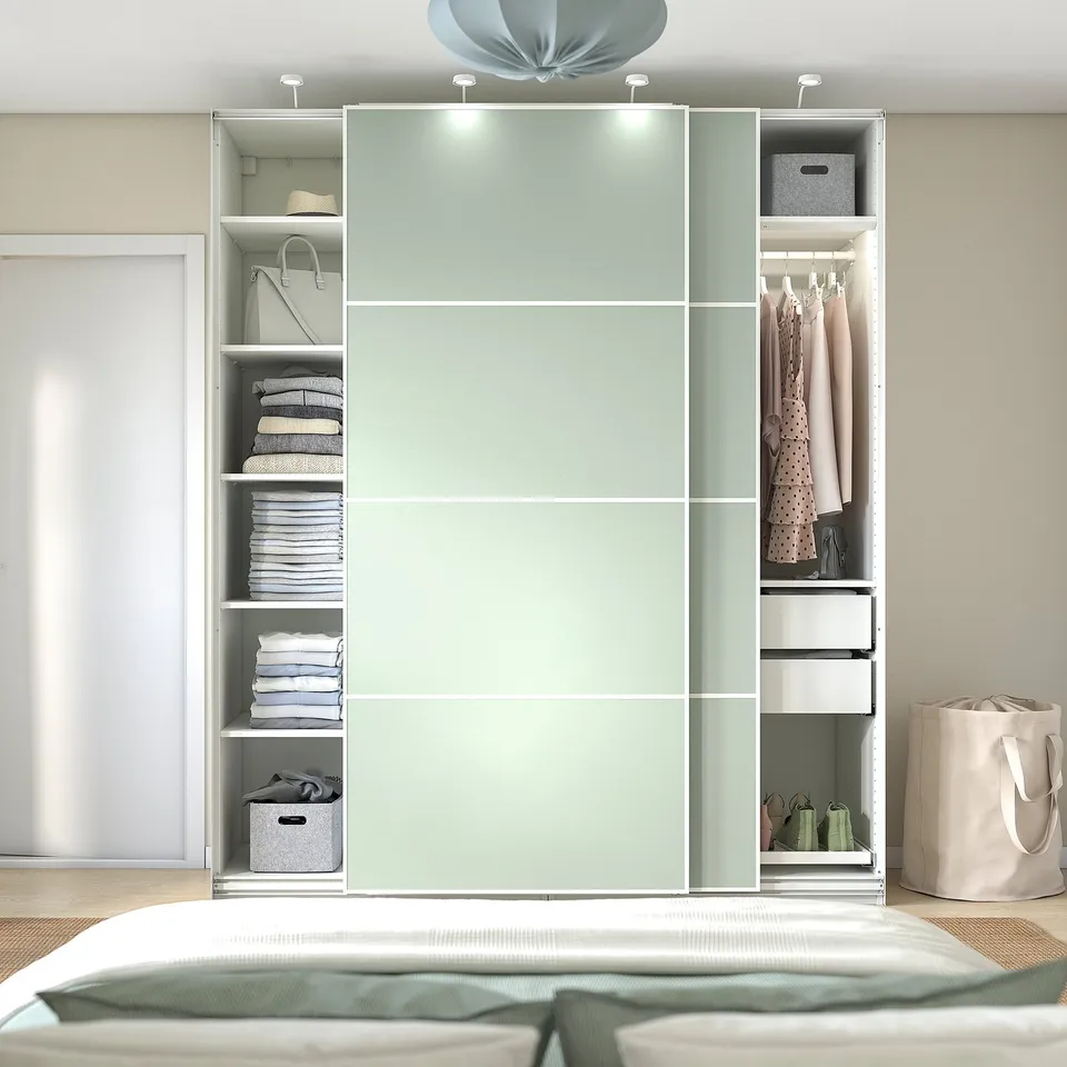 Modern bedroom with PAX wardrobe, open shelves, clothes, and light.