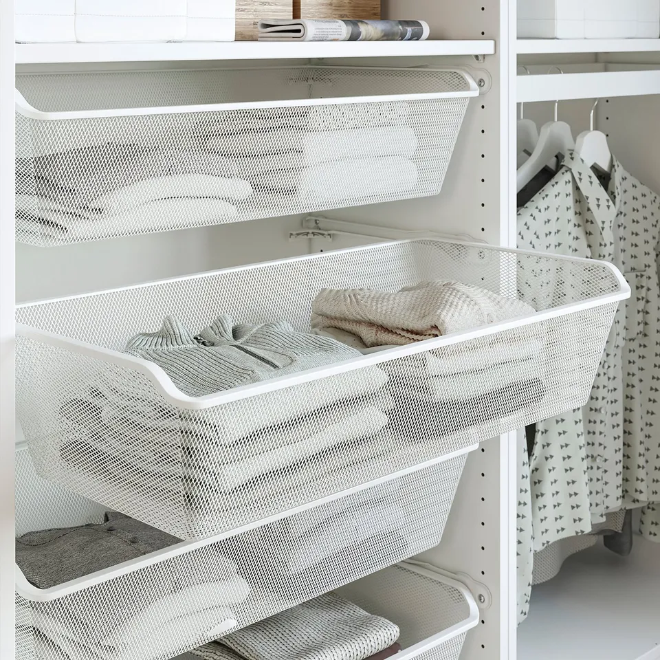 White mesh basket in closet for folded clothes, with additional compartments, part of PAX system.