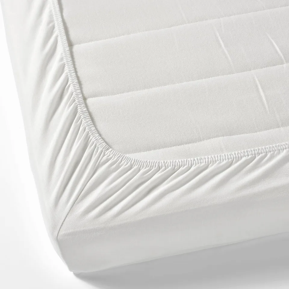 A fitted bed sheet with elastic corners, designed to tightly cover a mattress. Made of soft, breathable cotton ideal for a childs cot.