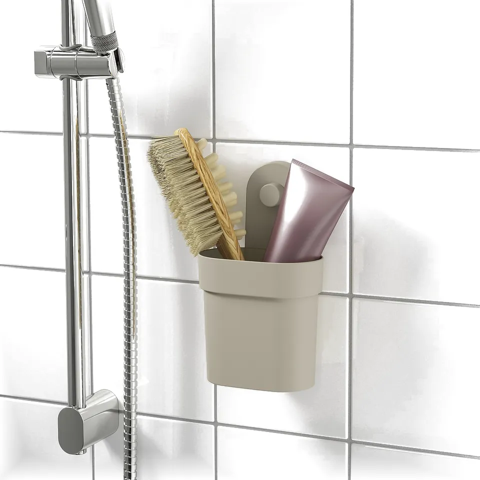 Shower caddy with suction cups attaches to tile wall, holding brush and bottles.