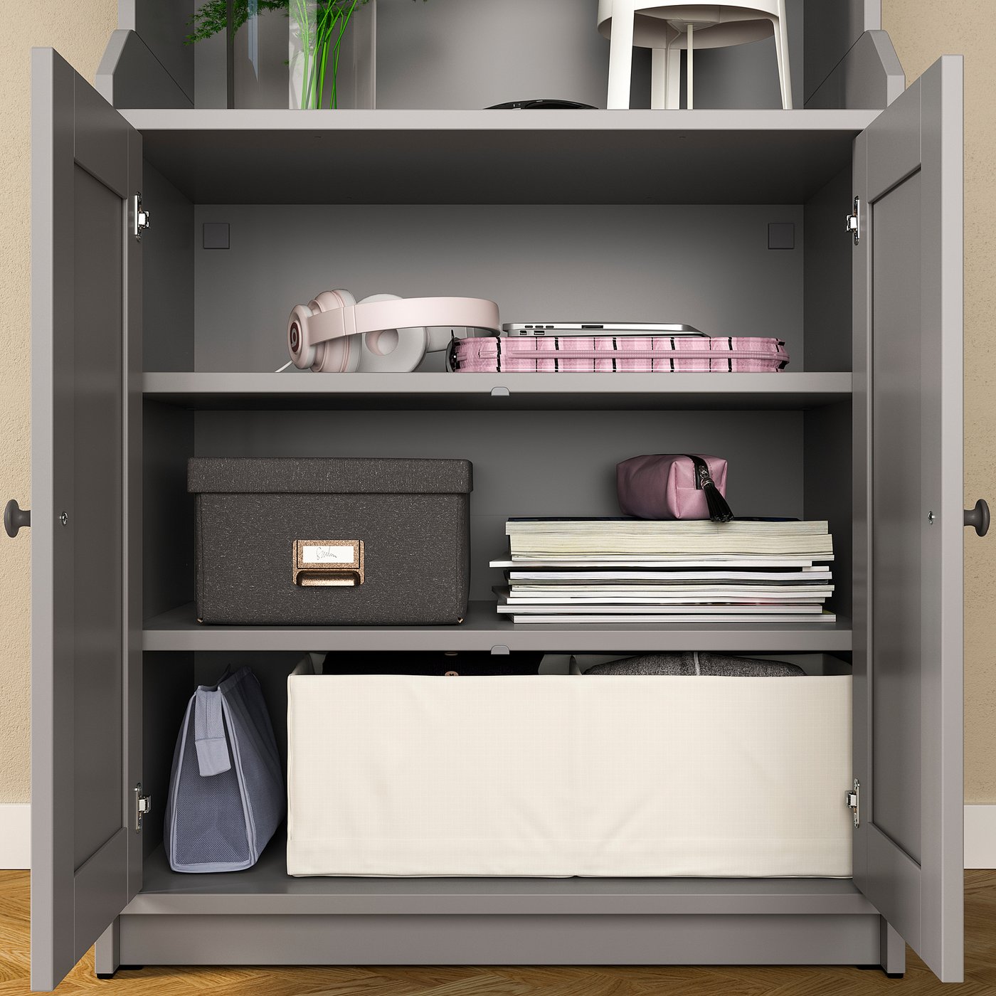 Open storage cabinet with shelves, holding boxes, papers, and bags. Grey colour, modern design, wooden material.
