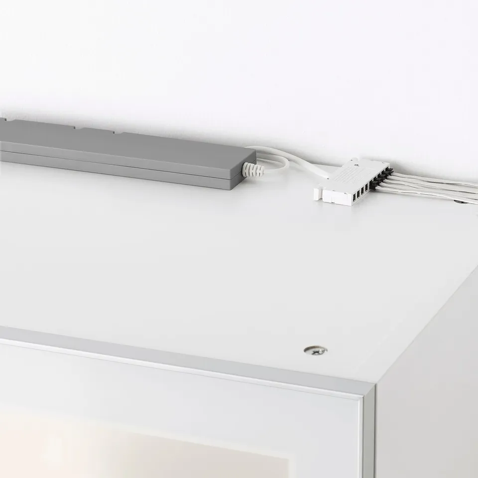 Ceiling-mounted smart lighting driver, part of IKEAs TRÅDFRI system, connected to multiple cables.